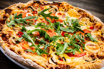 Pizza with ham and vegetables on wooden table 