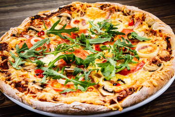 Pizza with ham and vegetables on wooden table 
