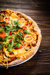 Pizza with ham and vegetables on wooden table 