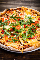 Pizza with ham and vegetables on wooden table 