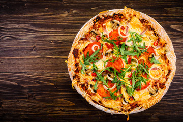 Pizza with ham and vegetables on wooden table 