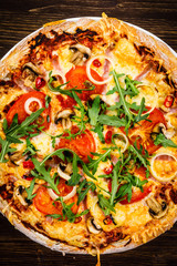 Pizza with ham and vegetables on wooden table 