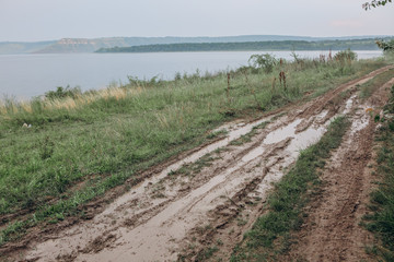 Fototapeta na wymiar road fishermen hunters river mud rut rain