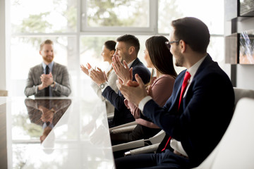 Businesspeople applauding while in a meeting at office