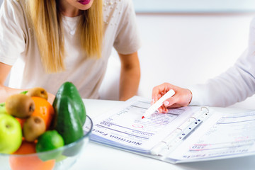 Nutritionist with female patient - obrazy, fototapety, plakaty