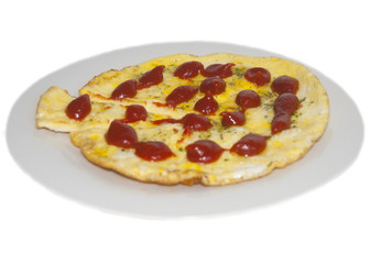 Fried eggs with greens, decorated with ketchup drops, on a white plate, isolated on a white background