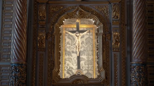 Monument Crucifixion of Jesus Christ Zoom In. Religious sculpture of Jesus christ crucified in a cross inside a golden Structure, zoom In