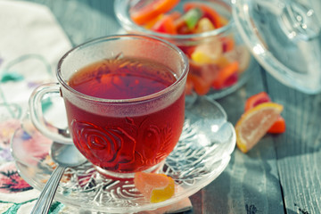 Close up of a morning black tea and colorful marmalades in glass jar on wooden table