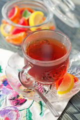 Close up of a morning black tea and colorful marmalades in glass jar on wooden table