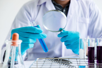 Biochemistry laboratory research, Scientist or medical in lab coat holding test tube with reagent...