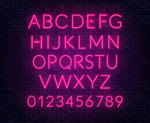 Neon pink alphabet on brick wall background. Capital letter.