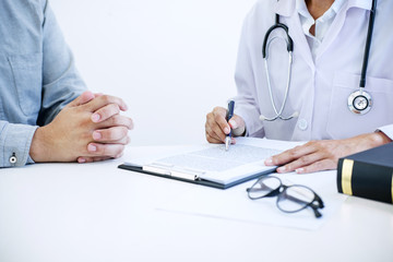 Doctor filling up an history form while consulting to patient and recommend treatment methods and how to rehabilitate