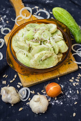 Fresh green salad with cucumber slices or pieces with onion rings, spices and herbs as part of healthy vegan lunch or vegetarian dinner served in plate. Healthy food.