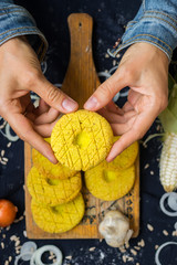 Woman hands holds Mchadi - traditional Georgian cornbread traditionally eaten with Lobio and suluguni  cheese. Mchadi corn bread of Georgia cuisine. Vegan vegetarian healthy food