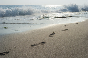 human footprints in the sand, surf, wave