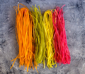 Colored Raw Vegetable Vegetarian Pasta with Beets, Carrots and Spinach. Flat lay. Copy space. Top view. Frame.
