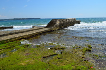 Betonowa plaża ze schodami, cała w zielonych glonach, Novigrad, Chorwacja © Ewa