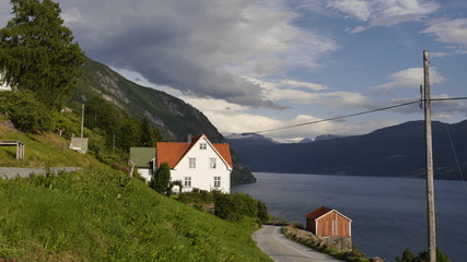 Fototapeta na wymiar Landwirtschaft am Innvikfjord, bunte Bauernhäuser am Hang