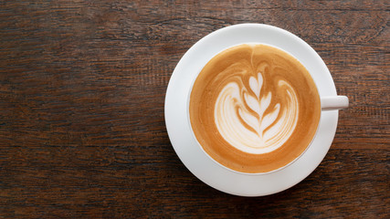 Hot coffee cappuccino latte art top view on wooden background