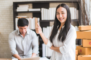 Fototapeta premium Happy young Asian man and woman at office of their business online shopping. 