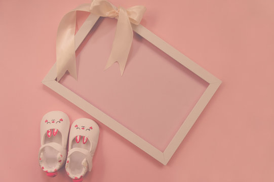 Childrens shoes for girls, stands on a pink background. on frame with ribbon. Closeup view from the top. the concept of children's clothing. Copyspace included.