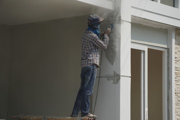 Worker is use abrasive equipment to decoration surface the house.