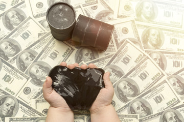 oil in the hands, barrels of oil, bills of American dollars. production, sale of petroleum products