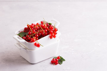Ripe red currant in white bowl