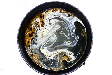 Dirty black frying pan with interesting unusual fatty stains on a white background