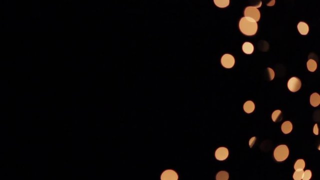 Blurred globular highlights of gold on black background