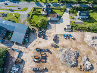 Aerial view of a recycling yard with trucks and containers.