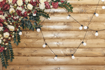 Obraz premium Decoration for wedding ceremony on wooden background with lamp garland. copy space