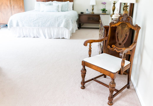 Bright white modern wooden rocking chair in nursery room bedroom with chest of drawers, bed, decorations in model staging home or house - Powered by Adobe
