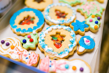 Tray gift paper box filled with many decorated icing glazed with candy sugar colorful artificial blue sprinkles Christmas holiday baked homemade cookies, snowmen