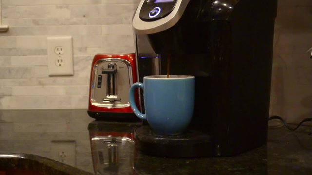 Brewing coffee into a blue mug