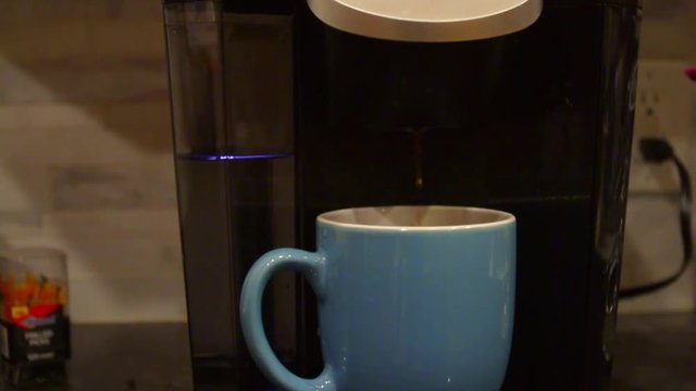 Brewing coffee into a blue mug