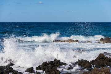 sea wave crashing on rocks