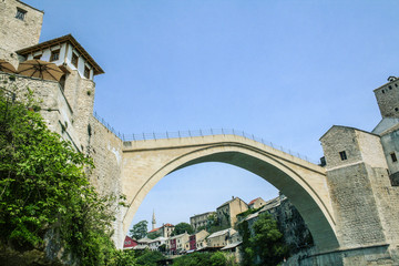 Fototapeta na wymiar Old Bridge of Mostar during a sunny afternoon, with the old city visible in the background. This bridge is the symbol of the war torn main city of Herzegovina, in Bosnia..