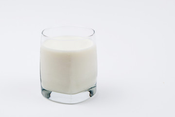 A glass full of milk on a white background. Isolated