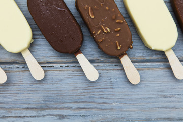 Chocolate ice cream lollies on a wooden background.