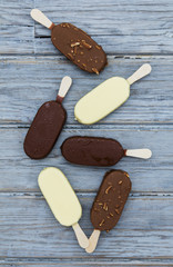 Chocolate ice cream lollies on a wooden background.