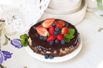Cake with fresh berries and cream on old wooden background. Selective focus.