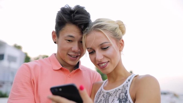 Young couple watch photos on smart phone when they together