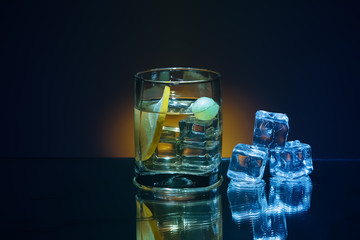 Ice and brandy or cognac in glass with slice of lemon