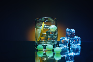 Ice and brandy or cognac in glass with slice of lemon