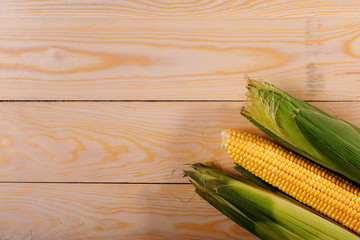 Ripe yellow corn wooden background. Healthy food. Top view.