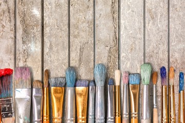 Row of artist paint brushes on background