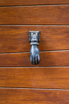 Hand Shaped Iron Door Knocker on a Panelled Wooden Door in Perouges, France