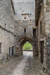 Fototapeta na wymiar Arched Tunnel Through a Stone Wall in Perouges, France