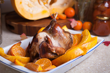Grilled guinea-fowl with tangerines in white form for cooking